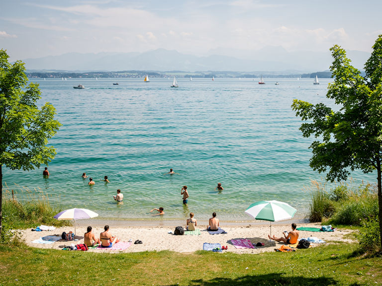 Naturstrandbad Kressbronn erleben und entspannt am Bodensee abkühlen Entspannte Badegäste genießen sonnigen Tag am Naturstrandbad Kressbronn Bodensee