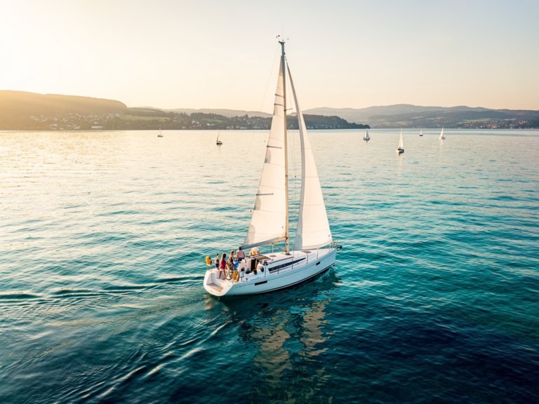 Segelboot auf Bodensee mit Seglern beim entspannten Törn im Sonnenschein