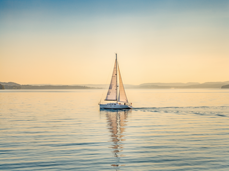 Segelboot auf ruhigem Untersee mit Alpenpanorama und blauem Himmel im Sommer