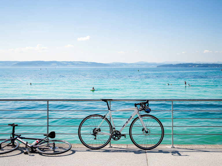 Radfahrer erfrischen sich an warmen Uferbädern des Bodensees im Sommer