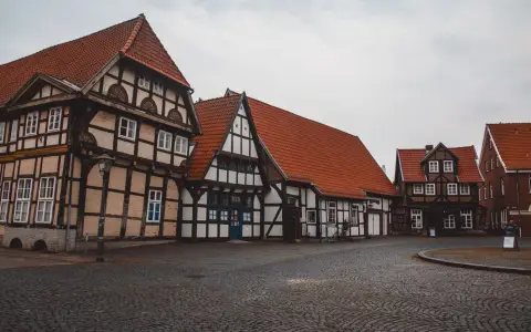 Symbolbild: Scenic view of a historic village square with traditional half-timbered houses and cobblestone paving.