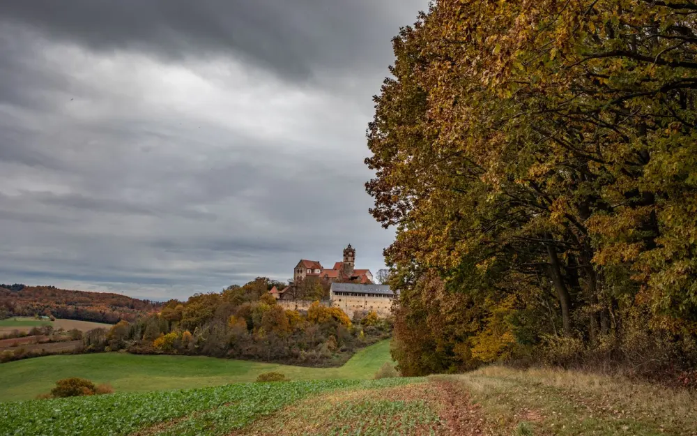 Symbolbild: Ronneburg Castle amidst autumn foliage under a dramatic cloudy sky in Hessen, Germany.