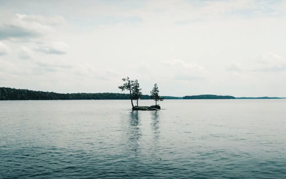 Symbolbild: Peaceful waters surround a tiny island under a bright sky in Perth, Ontario.