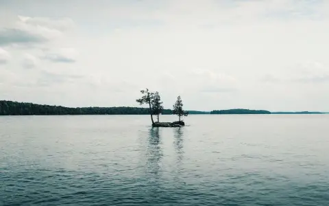 Symbolbild: Peaceful waters surround a tiny island under a bright sky in Perth, Ontario.