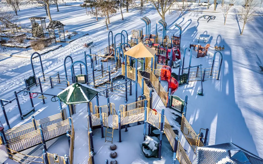 Symbolbild: Aerial view of a snow-covered playground in Red Wing, MN, capturing serene winter beauty.