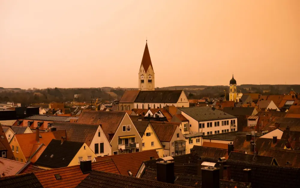 Symbolbild: Explore a picturesque sunset over Kaufbeuren's rooftops and iconic church towers.