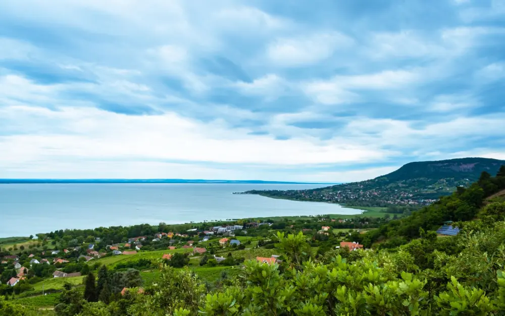 Symbolbild: Panoramic view of Badacsonytomaj and Lake Balaton under a cloudy sky in Hungary.