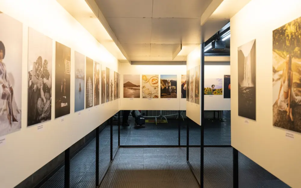 Symbolbild: A well-lit art exhibition featuring diverse photographic prints in a modern indoor gallery.