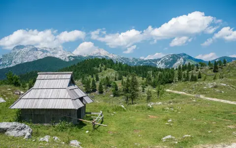 Symbolbild: Scenic view of a rustic cabin in Kamnik, Slovenia with a mountainous backdrop.