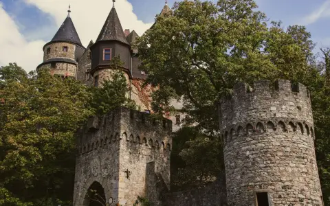 Symbolbild: Explore the enchanting towers and historic architecture of Braunfels Castle amidst lush greenery.