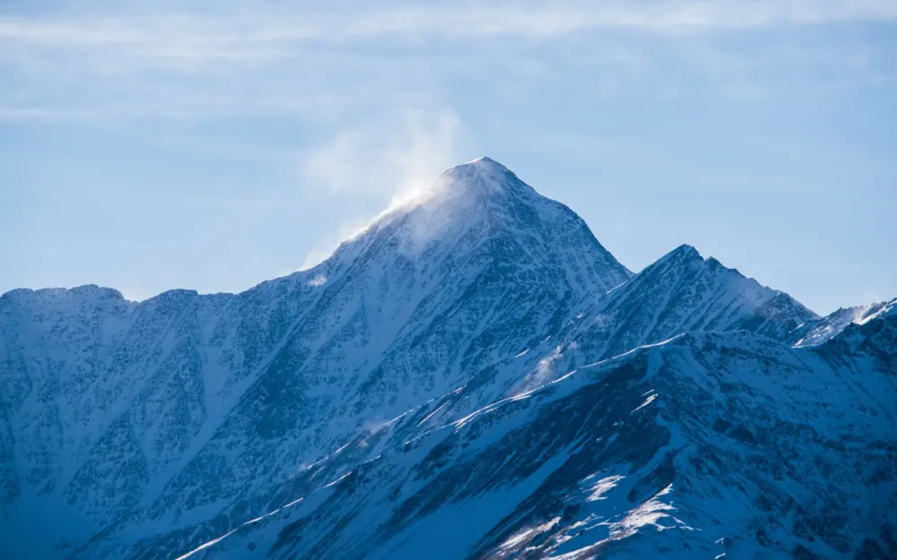 Symbolbild: Serene snow-capped mountains with sunlight streaming over peaks in Chechnya.