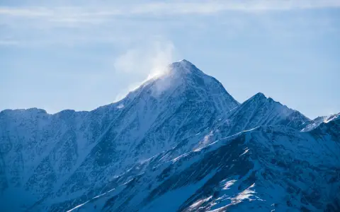 Symbolbild: Serene snow-capped mountains with sunlight streaming over peaks in Chechnya.