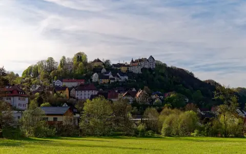 Symbolbild: Picturesque hillside village of Egloffstein in Bavaria, Germany, surrounded by lush greenery.
