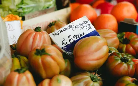Symbolbild: Close-up of organic tomatoes in a vibrant market setting, showcasing fresh produce.