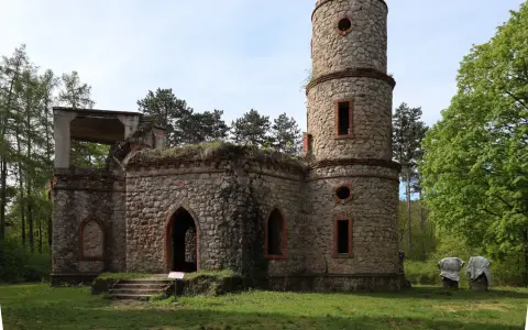 Symbolbild: Explore the mystery and history of a medieval stone ruin set amid lush, green forest foliage.