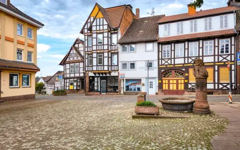 Symbolbild: Quaint cobblestone square with traditional European architecture in a serene setting.