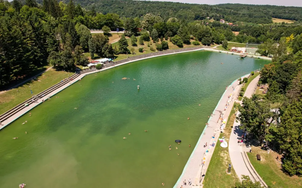 Symbolbild: Aerial view of Orahovica Lake in Croatia, capturing summer leisure activities and lush green surroundings.