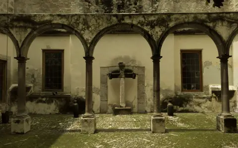 Symbolbild: Historic cloister with gothic arches and vintage stone textures, evoking a serene atmosphere.