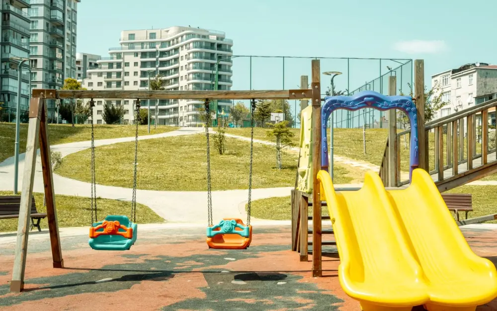 Symbolbild: Colorful playground with swings and slide, perfect for outdoor fun and leisure.