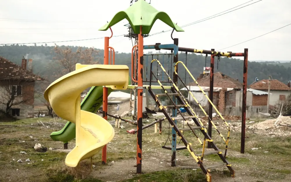 Symbolbild: An old, abandoned playground slide and climbing structure in a rural area.