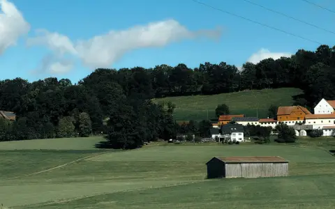 Symbolbild: Scenic countryside view in Bad Berneck, Germany, with fields and farm buildings.