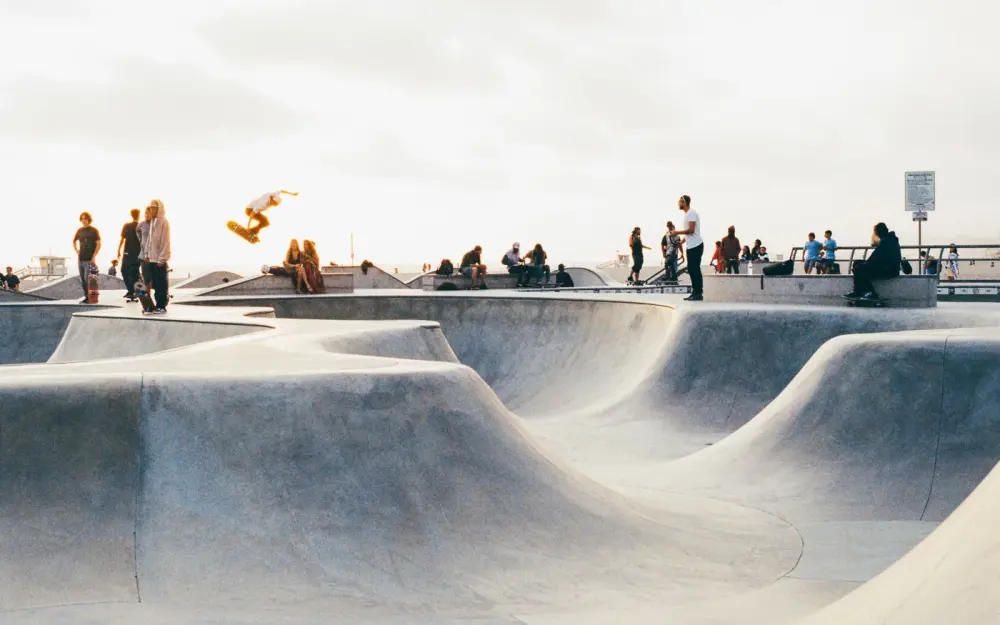 Symbolbild: A vibrant scene of skateboarders performing tricks at a lively outdoor skatepark.