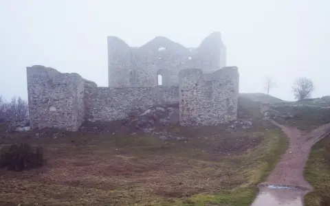 Symbolbild: Ruined stone fortress in a misty landscape, conveying a sense of mystery and history.