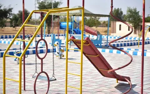 Symbolbild: Vibrant playground with slides and swings in outdoor park setting.