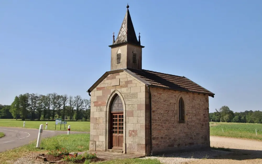 Symbolbild: A quaint stone church set in the rural landscape of Selles, Normandie, captured on a sunny day.