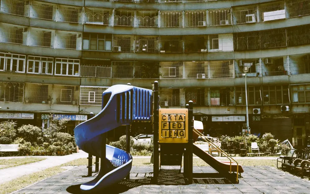 Symbolbild: A colorful playground set against a vintage apartment in Taipei, showcasing urban exploration.
