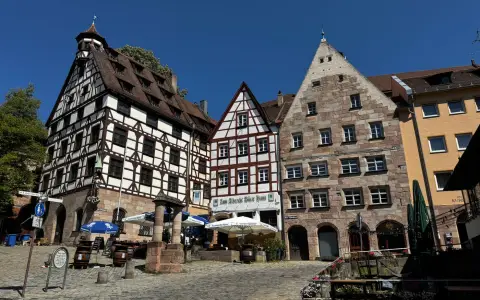 Symbolbild: Historic half-timbered buildings in Nuremberg's old town under clear blue skies, capturing medieval charm.