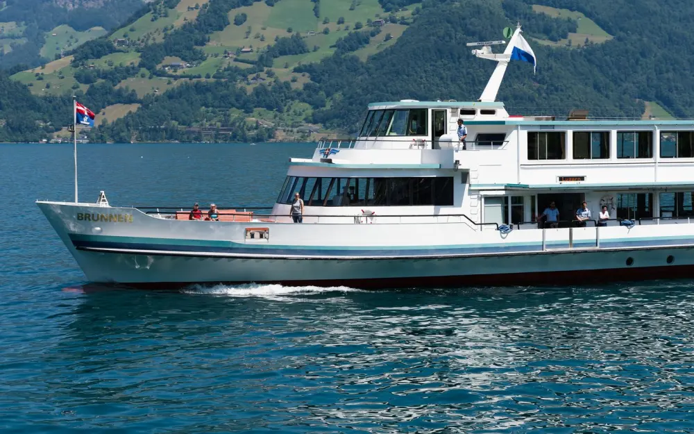 Symbolbild: Passenger boat sailing on Lake Lucerne surrounded by Swiss Alps, providing scenic views.
