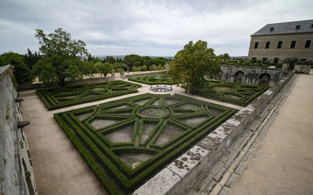 Symbolbild: A symmetrical geometric garden in a historic Spanish palace, showcasing intricate hedges and pathways.