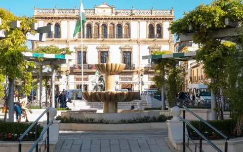 Symbolbild: Charming fountain in a historic plaza with ornate building in Málaga, Spain.