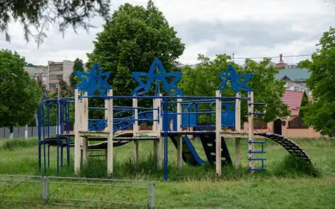 Symbolbild: Colorful playground structure featuring star shapes in a lush green park.