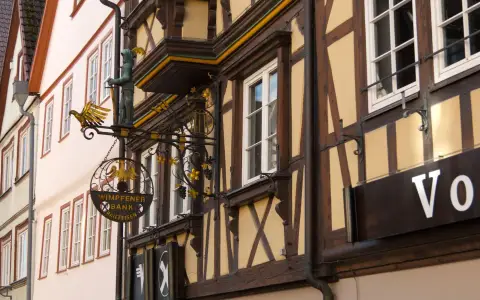 Symbolbild: Charming half-timbered building with intricate signage in Germany's scenic townscape.