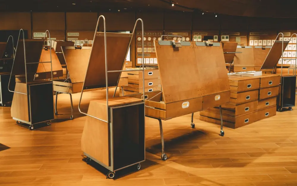 Symbolbild: Interior view of a modern art gallery with wooden exhibition stands and artwork displays.