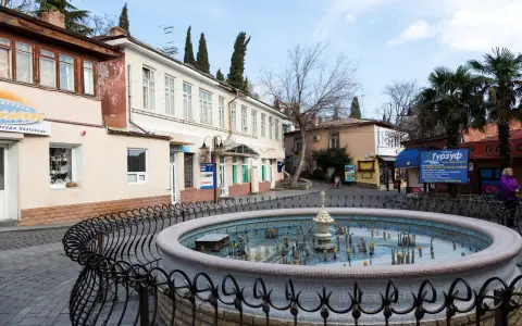 Symbolbild: Quaint street scene with a decorative fountain and unique architecture.