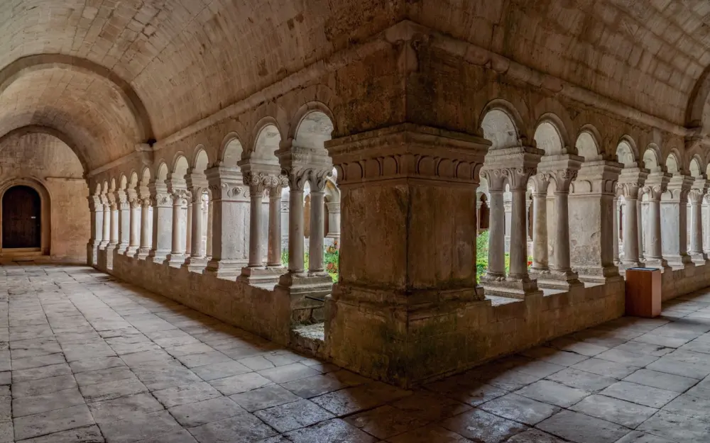 Symbolbild: Explore a serene and ancient stone cloister with beautiful arches and intricate columns.