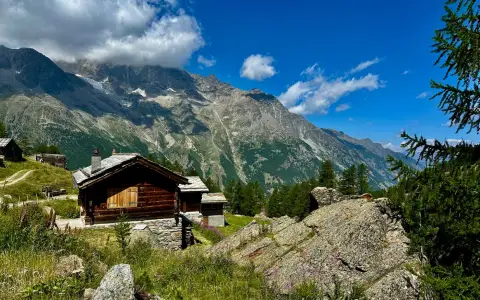 Symbolbild: A scenic view of a traditional cabin in the Swiss Alps with majestic mountains in the background.