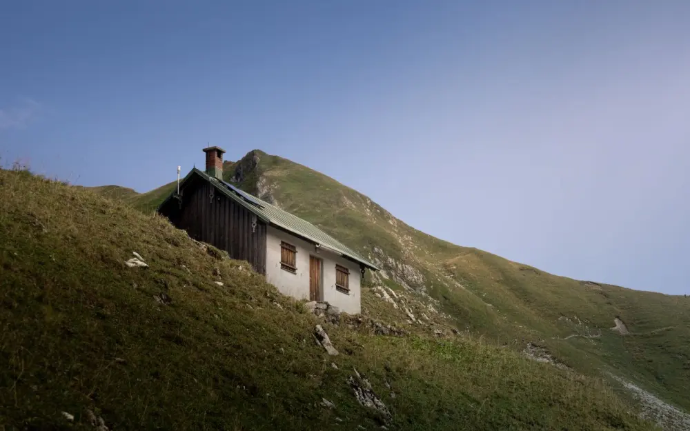 Symbolbild: Rustic cabin on hillside in Bad Hindelang, showcasing serene mountain landscape.