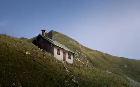 Symbolbild: Rustic cabin on hillside in Bad Hindelang, showcasing serene mountain landscape.