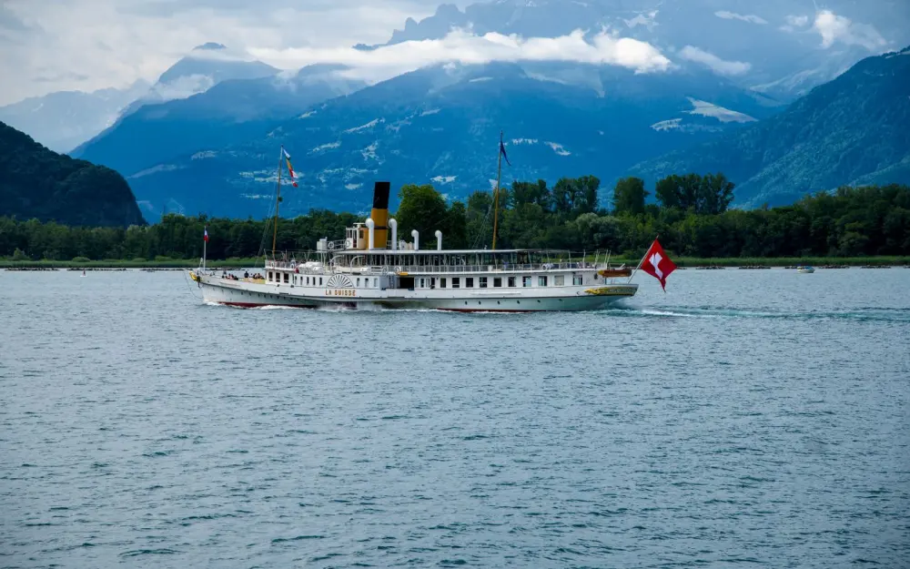 Symbolbild: Historic paddle steamer La Suisse cruising on Lake Geneva with scenic mountain backdrop.