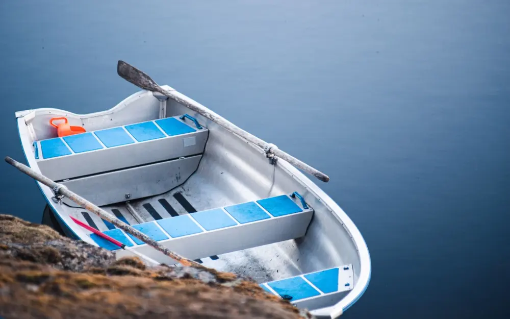 Symbolbild: A peaceful scene with a rowboat floating on a calm lake, offering tranquility and solitude.