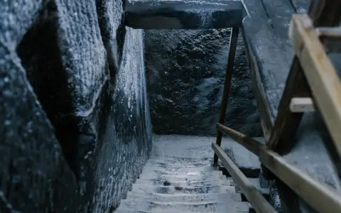 Symbolbild: From above of aged stone stairway covered with salt in ancient cave with shabby walls and wooden railings in Registry Chamber of Salina Turda mine