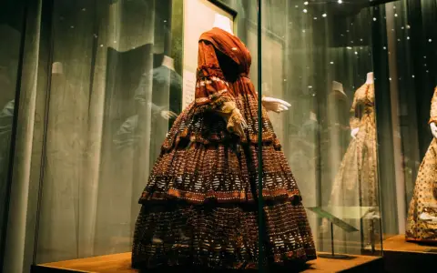 Symbolbild: Colorful ornamental old style feminine costume with sleeves on mannequin on exhibition in museum
