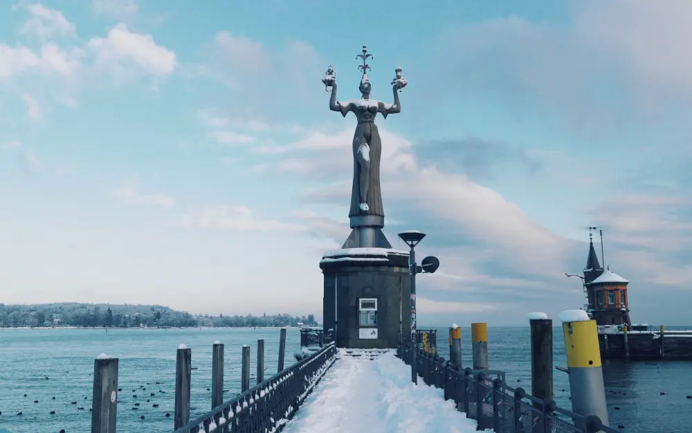The majestic Imperia statue in Konstanz, Germany, standing proudly with a snow-covered harbor backdrop.