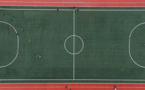 Symbolbild: Aerial shot of a soccer match on a green field with players in Lviv, Ukraine.