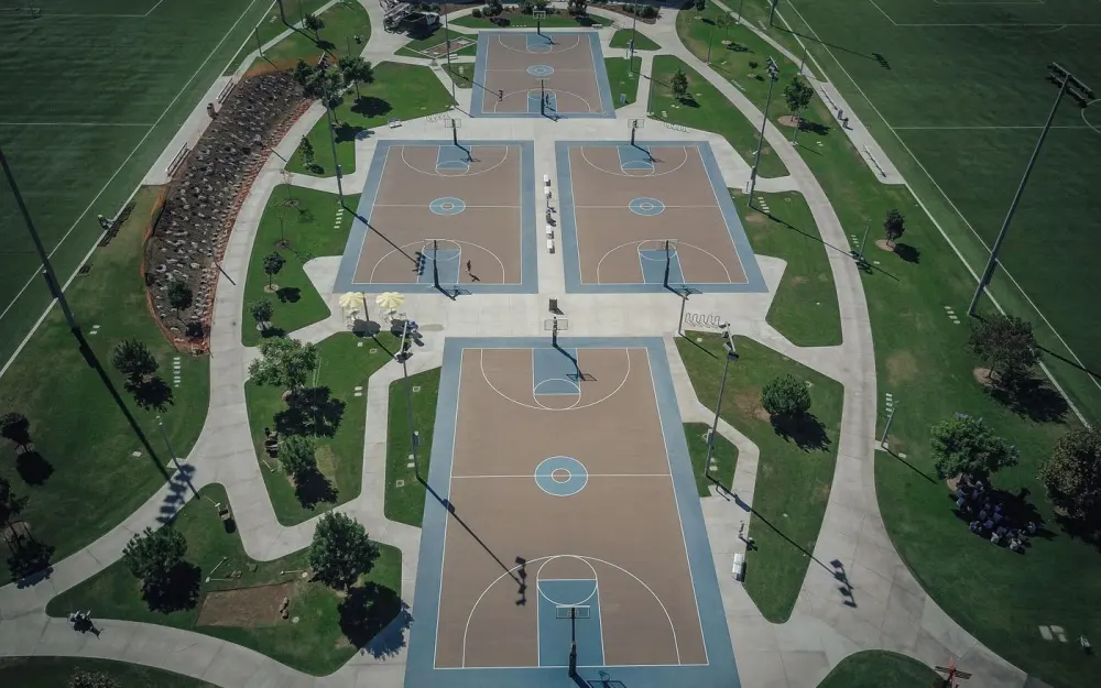 Symbolbild: Drone shot of multiple basketball courts in a recreational park.